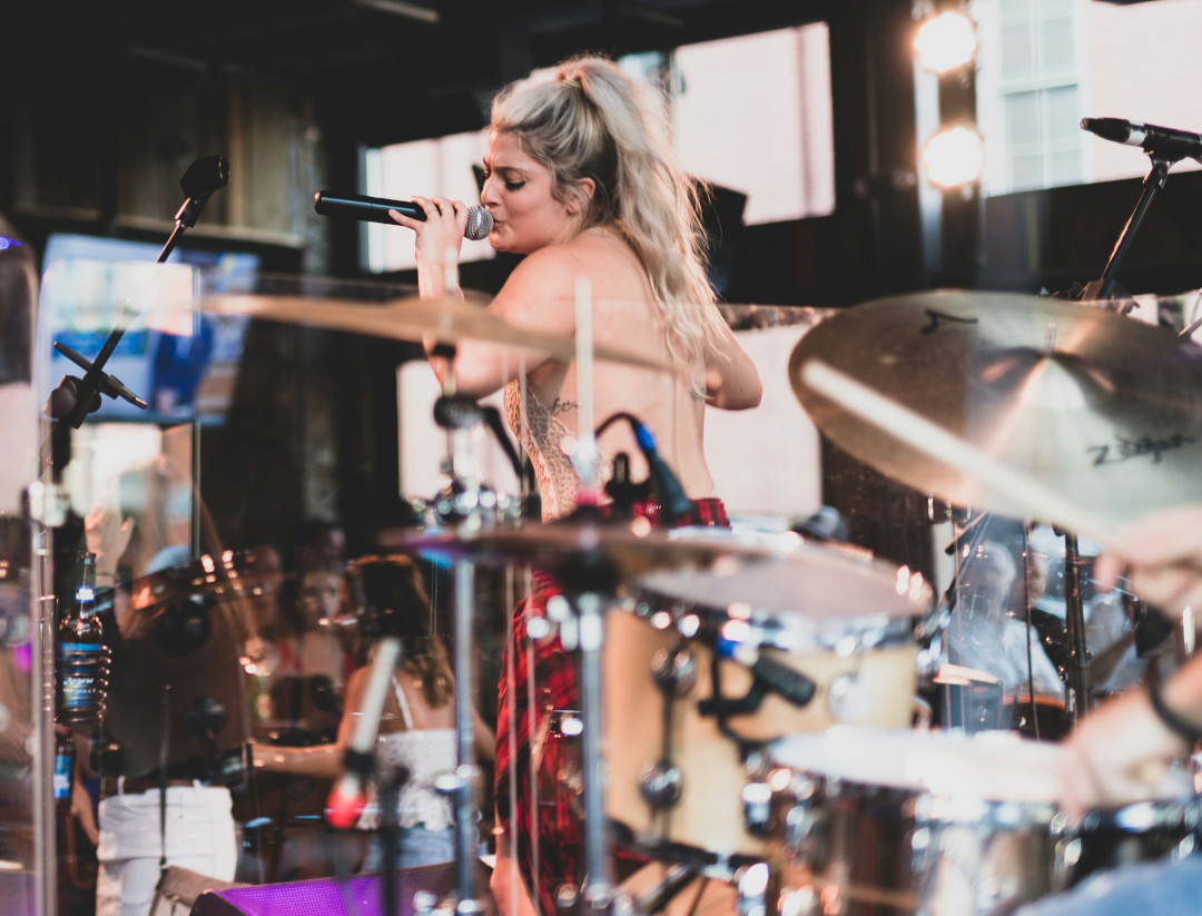 Photo of woman singing with a band on a stage